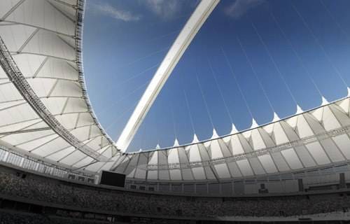 View of a stadium roof with a blue sky.