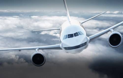 A commercial airplane flying through cloudy skies.