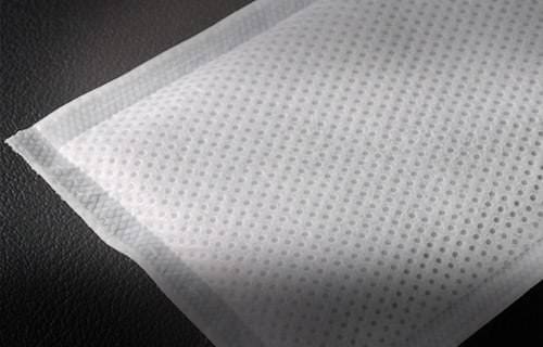 Close-up of textured white fabric with small perforations.