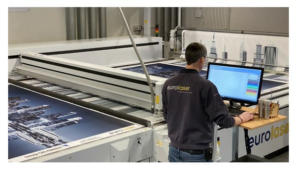 Person operating a large format laser cutter.